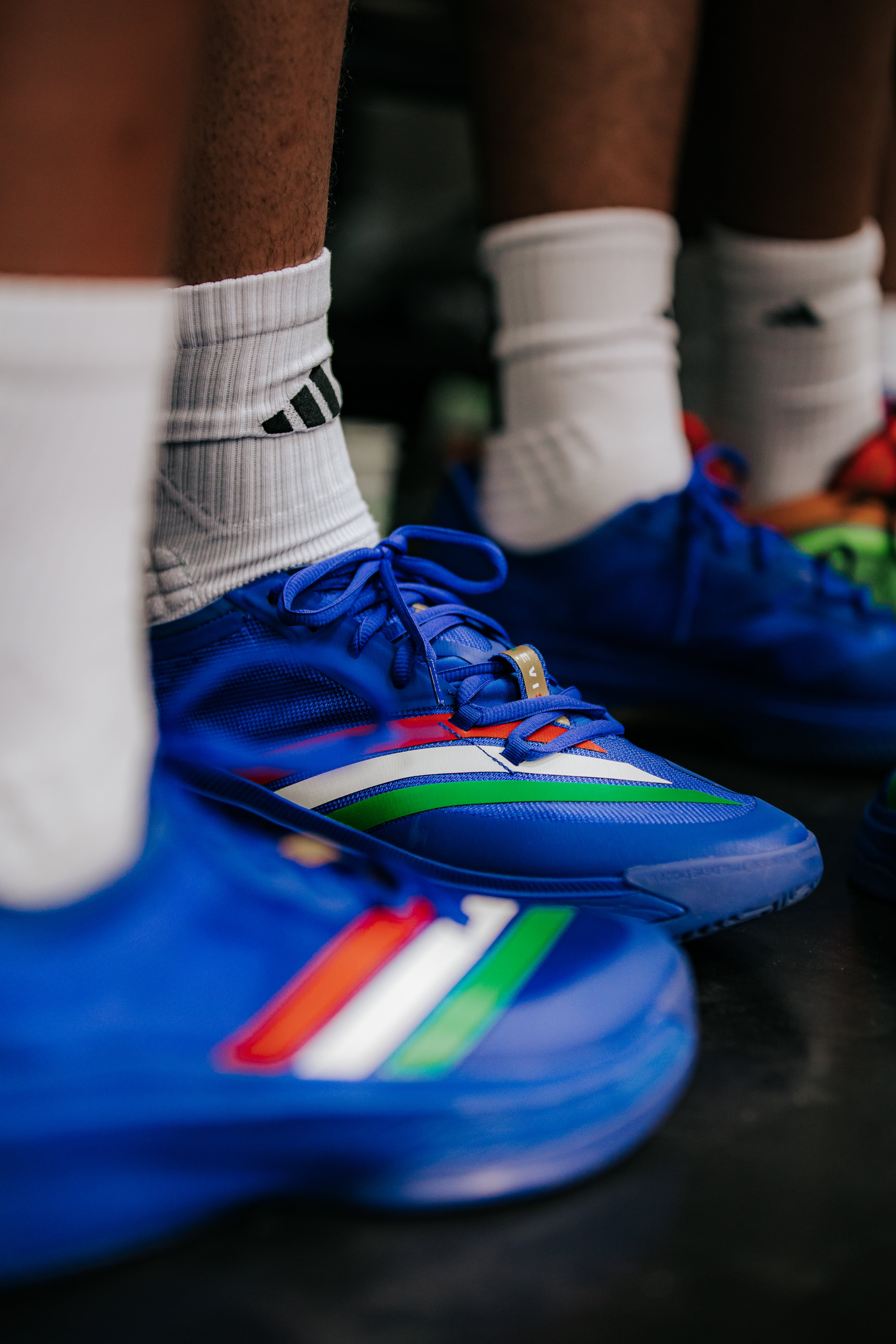 Close-up of blue adidas basketball shoes with colorful stripes worn during Eurocamp 2025